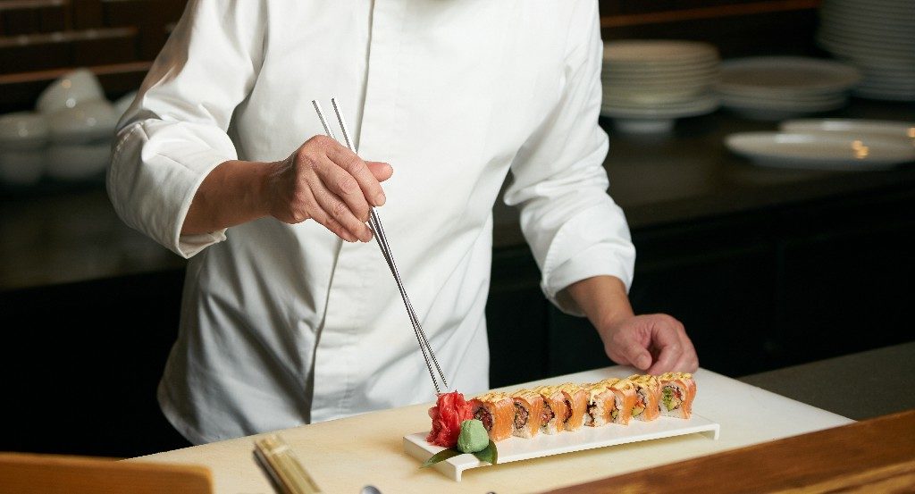 Sushi Chef lining up Sushi Rolls
