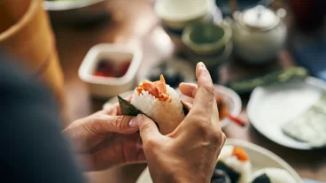 Onigiri being delicately wrapped with filling